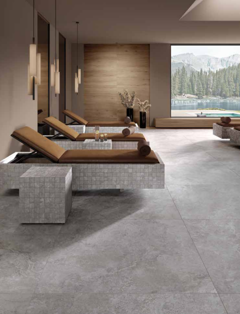 Tuscania Dolomia Stone 'Grey', grijze natuursteenlook vloertegels in een wellnessruimte met ligbedden en bergmeeruitzicht