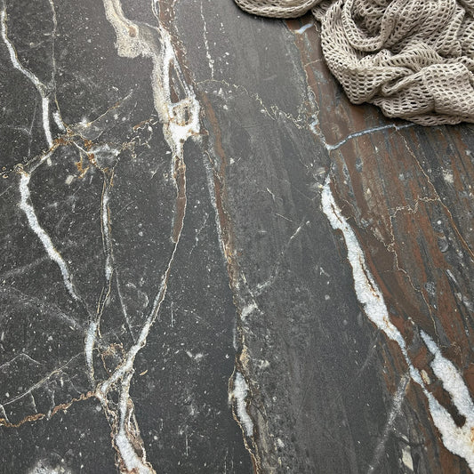La Platera Dusk 'Black', detail van zwarte marmerlook tegel 60x60cm met witte en roestbruine aders