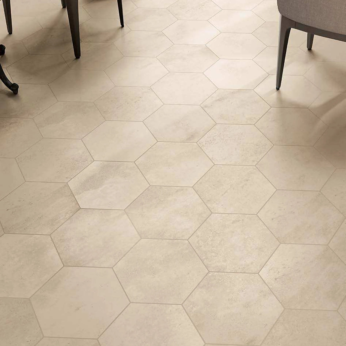 Castelvetro Fusion 'Bianco', crèmekleurige zeshoekige vloertegels van dichtbij onder twee stoelen