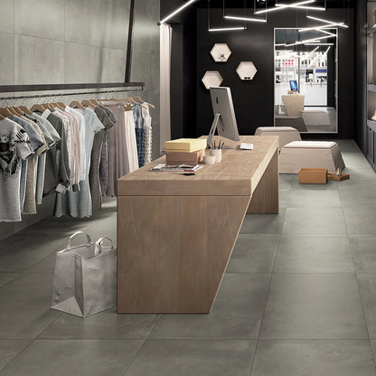 Castelvetro Fusion 'Piombo', grijze wand- en vloertegels in groot formaat in een winkel met een houten toonbank