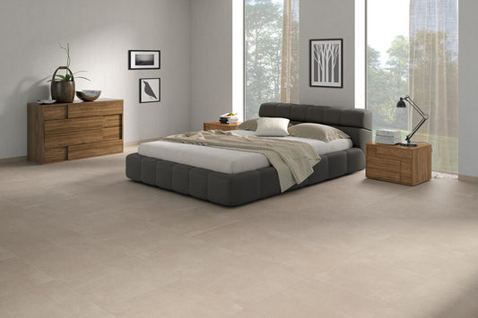 Ceramica Valsecchia Galaxy 'Beige', beige betonlook vloertegels in een slaapkamer met grijs bed en houten dressoir