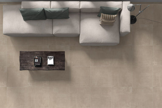 Ceramica Valsecchia Galaxy 'Beige', taupe betonlook vloertegels van bovenaf met een lichte hoekbank en donkere salontafel