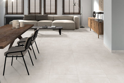 Ceramica Valsecchia Galaxy 'White', crèmewitte betonlook vloertegels in een woonkamer met houten eettafel en lichte bank