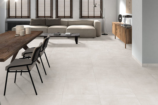 Ceramica Valsecchia Galaxy 'White', crèmewitte betonlook vloertegels in een woonkamer met houten eettafel en lichte bank