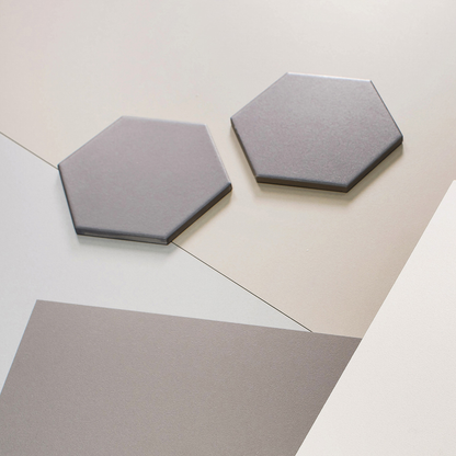 Argenta Cerámica Gallery 'Grey', twee grijze zeshoekige tegels los op een licht en een grijs vlak