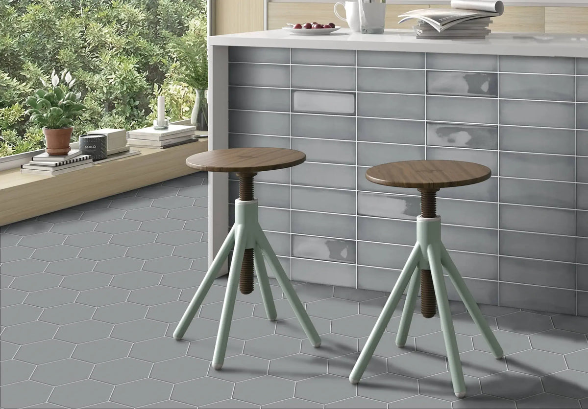 Estudio Cerámico Ghent 'Pearl Grey', grijze glanzende wandtegels als barfront in een keuken met houten krukken