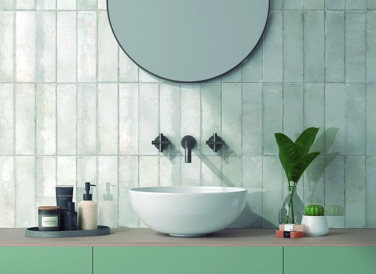 Estudio Cerámico Hackney 'Artic', witte wandtegels in een badkamer met ronde spiegel en mintgroen wastafelmeubel