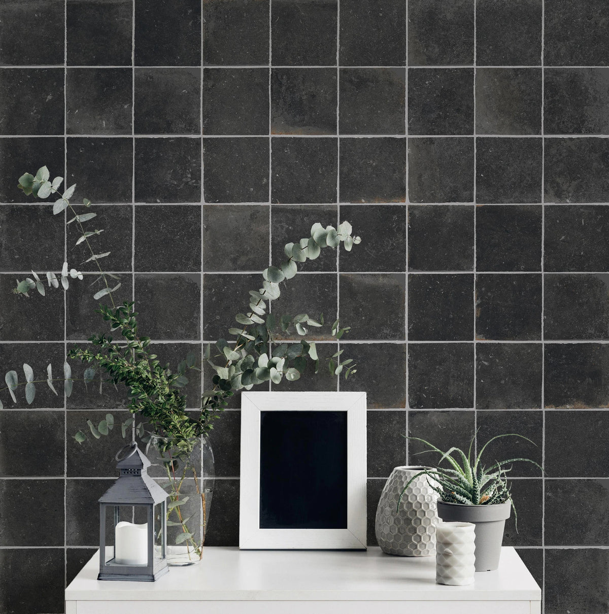 Savoia Italia Heritage 'Charcoal', antracieten wandtegels achter een witte console met lantaarn, eucalyptus en fotolijst