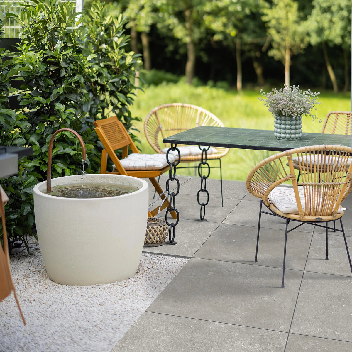Savoia Italia Heritage 'Grey', grijze terrastegels, hier 60x60cm gerectificeerd en 2cm dik, op een terras met rotan stoelen