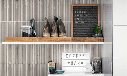 Keradom Home 'Ash', grijze Kit-Kat wandtegels achter een koffiehoek met houten plank, koffiekannen en een letterbord