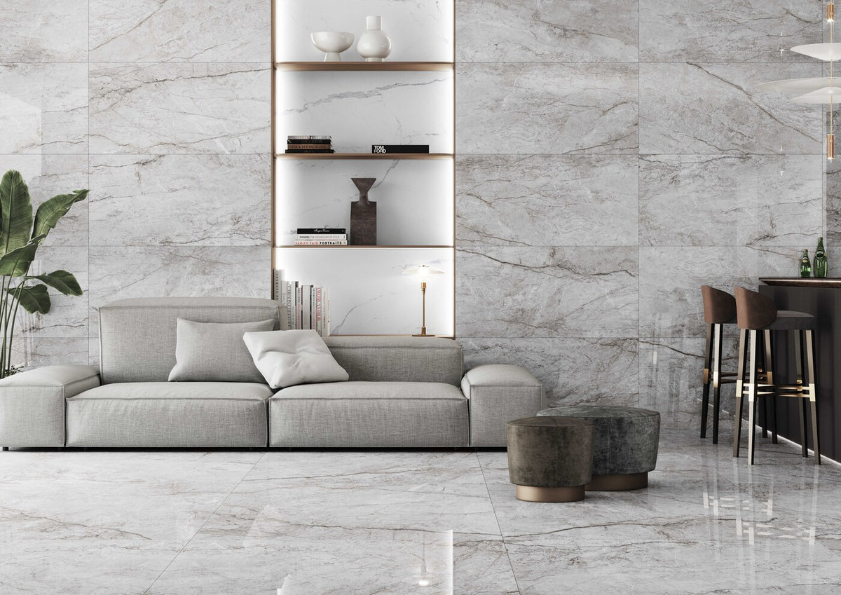 Keraben Idyllic 'Grey', lichtgrijze glanzende marmerlook vloer- en wandtegels in een woonkamer met lichte bank en wandnissen
