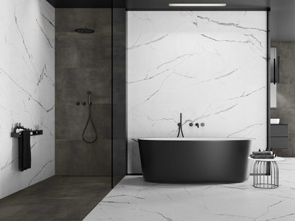 Keraben Idyllic 'White', witte marmerlook wand- en vloertegels in een badkamer met inloopdouche, zwart bad en accentwand