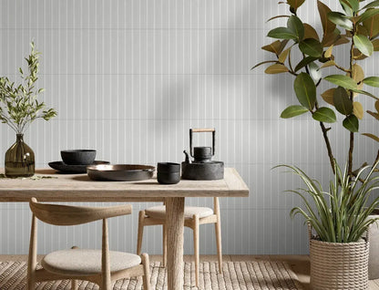 Estudio Cerámico Jaipur 'Snow', witte wandtegels met fijn verticaal ribbelreliëf in een eetkamer met tafel en zwart servies
