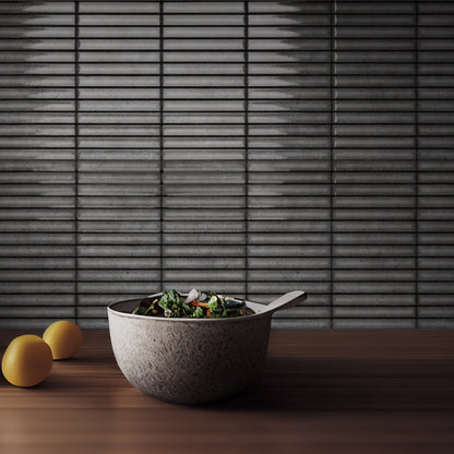 Estudio Cerámico Karatsu 'Charcoal Grey', antraciet geribbelde tegelwand achter een houten werkblad met schalen