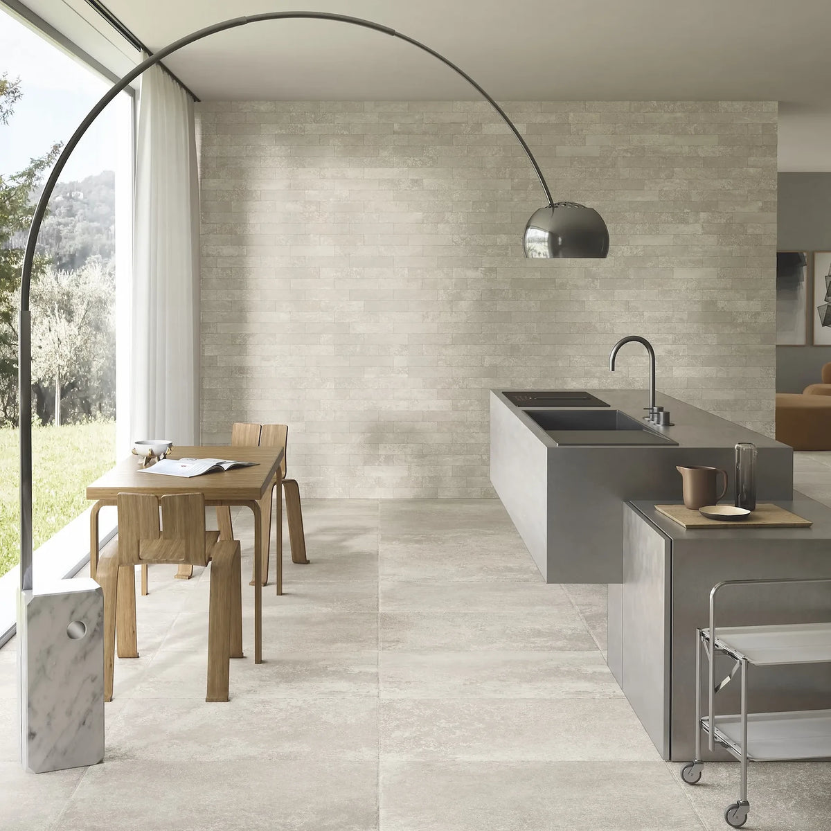 Ceramica Gazzini Lava Stone 'Shadow', crèmekleurige vloertegels, hier 60x90cm, in een keuken met kookeiland en booglamp