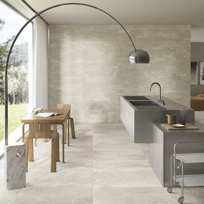 Ceramica Gazzini Lava Stone 'Shadow', crèmekleurige vloertegels, hier 60x90cm, in een keuken met kookeiland en booglamp
