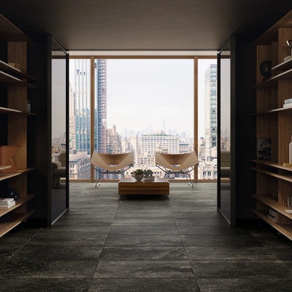 Ceramica Gazzini Lava Stone 'Black', zwarte vloertegels, hier 60x90cm, in een gang met boekenkasten en uitzicht op de stad