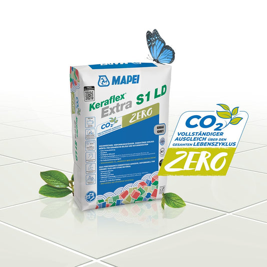 Zak Mapei Keraflex Extra S1 LD Zero op een witte tegelvloer met blad en het CO2 Zero-logo
