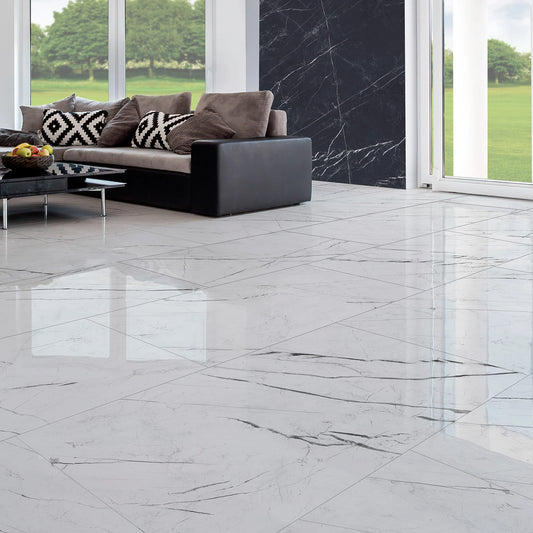 EnergieKer Marquiña 'White', gepolijste vloertegels 60x120 in een lichte woonkamer met zwarte bank en tuinzicht