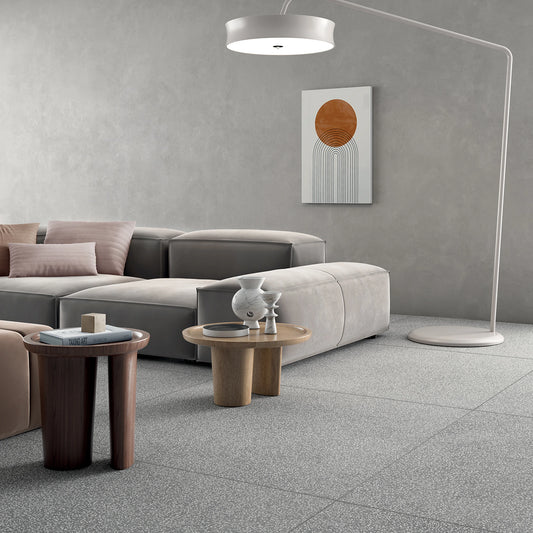 Lea Ceramiche Masterpiece 'Piece Light', Piece Light 120x120 op de vloer van een woonkamer met grijze bank en booglamp