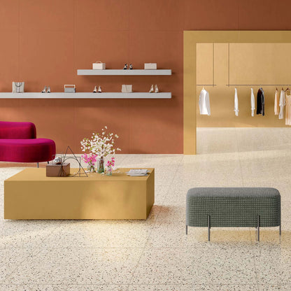EnergieKer Medley 'Cream', vloer 120x120cm in een winkel met terracotta wand en okergele tafel