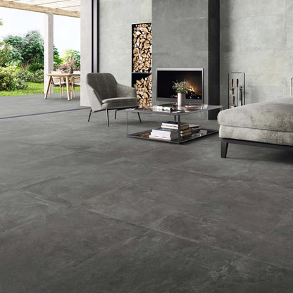 STN Cerámica Merlot 'Graphite', donkergrijze vloertegels 60x120cm in een woonkamer met haard en lichtere wand