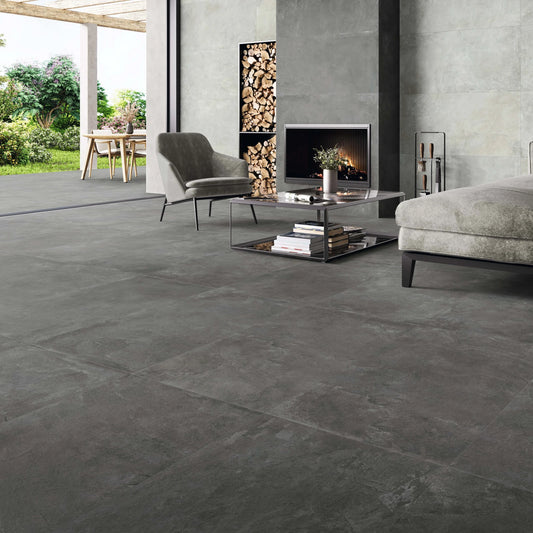 STN Cerámica Merlot 'Graphite', donkergrijze vloertegels 60x120cm in een woonkamer met haard en lichtere wand