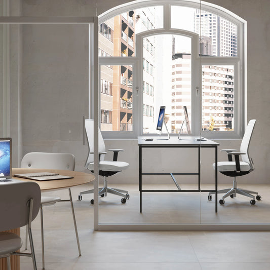 Casalgrande Padana Metropolis 'Metro Almond', beige vloertegels 120x120cm in een kantoor met boograam en witte bureaustoelen
