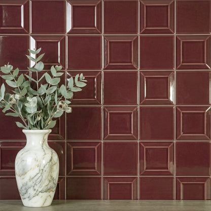 Estudio Cerámico Metropolis 'Dark Red', bordeauxrode wandtegels achter een witte marmeren vaas met eucalyptus