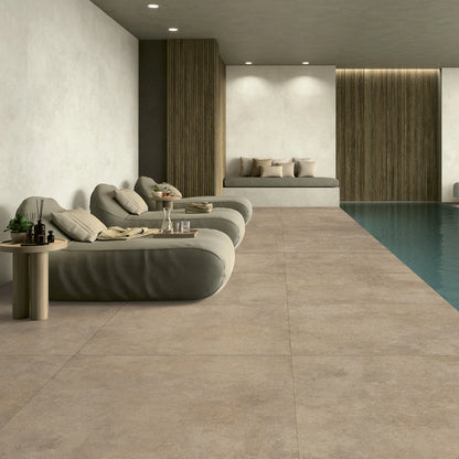 EnergieKer Miro 'Amber', beige-bruine tegels, hier als vloer van 120x120cm rond een binnenzwembad met ligbedden