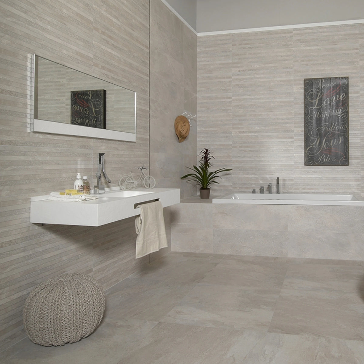 Keraben Nature 'Bone', crème-witte wandtegels 30x90, deels met lijnendecor, in een badkamer met wastafel en poef
