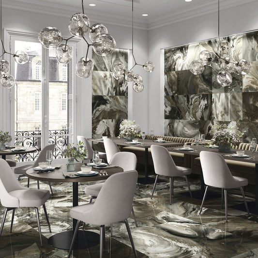 Baldocer Cerámica Nexside 'Bron', bruingrijze marmerlook wandpanelen in een restaurantzaal met glazen hanglampen