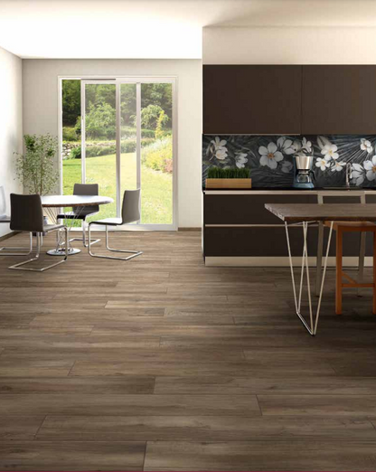 Tuscania North Wind 'Melange', donkerbruine houtlook vloertegels in een open keuken met eettafel en tuindeuren naar de tuin