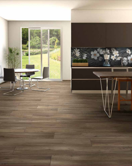 Tuscania North Wind 'Melange', donkerbruine houtlook vloertegels in een open keuken met eettafel en tuindeuren naar de tuin