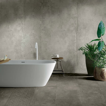 EnergieKer Parker 'Grey', grijze wandtegels, hier 120x280cm met mozaïek, in een badkamer met vrijstaand bad en plant