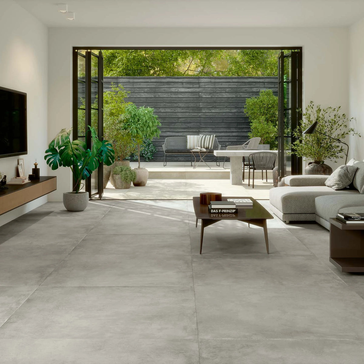 EnergieKer Parker 'Silver', lichtgrijze vloertegels, hier 120x120cm, in een woonkamer met openslaande deuren naar het terras