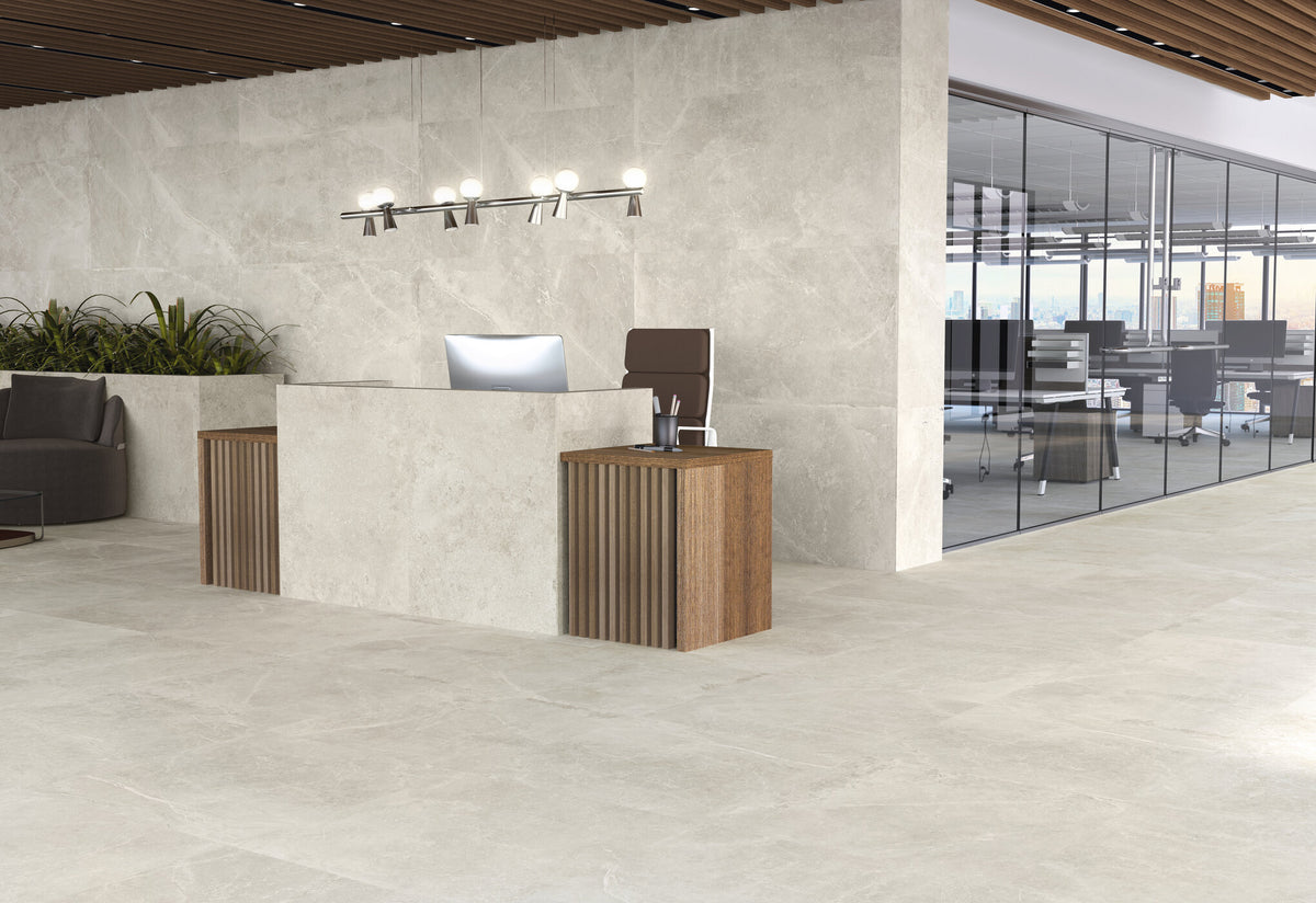 Azulejos Benadresa Pietra Antica 'Crema', beige steenlook tegels in een kantoorentree met receptiebalie en glazen wand