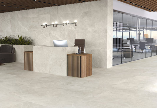 Azulejos Benadresa Pietra Antica 'Crema', beige steenlook tegels in een kantoorentree met receptiebalie en glazen wand