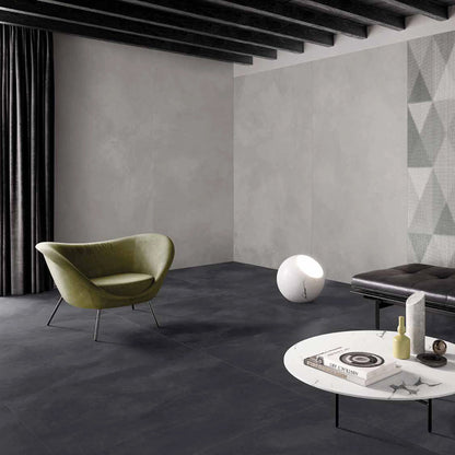Casalgrande Padana Pietre di Sardegna 'Caprera', grijze wand, hier 120x240cm, met antraciet vloer en groene fauteuil