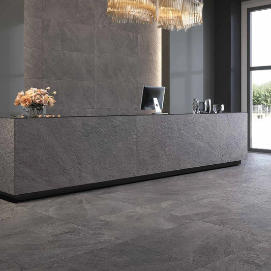 Castelvetro Slate 'Antracite', ontvangsthal met vloer 100x100 en wand 60x120 achter een balie met leisteenlook