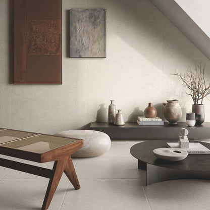 Casalgrande Padana Stile 'White Smoke', crème anticata-vloer 60x60cm en diagonaal gestructureerde wand in een woonkamer