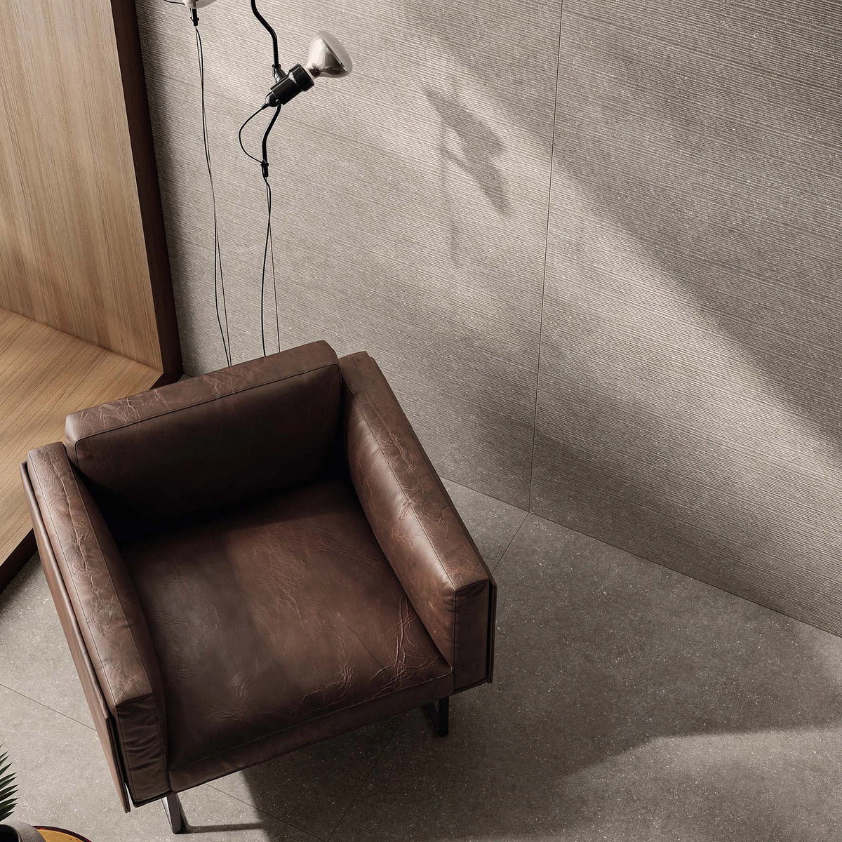 Casalgrande Padana Stile 'French Grey', grijze vloer 120x120cm en geribbelde wand 60x120cm met een leren fauteuil