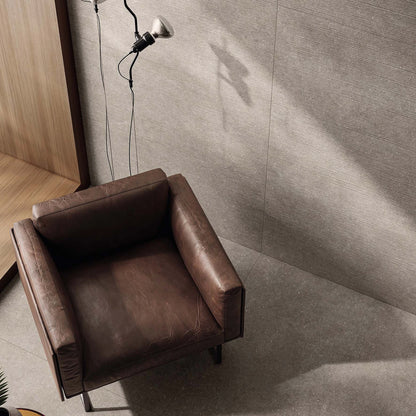 Casalgrande Padana Stile 'French Grey', grijze vloer 120x120cm en geribbelde wand 60x120cm met een leren fauteuil