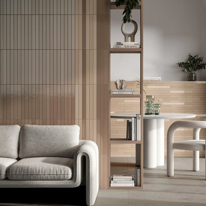 Keradom Twiggy 'Nudo', beige wandtegels in mat en glans achter een bank, met open boekenkast en ronde eettafel