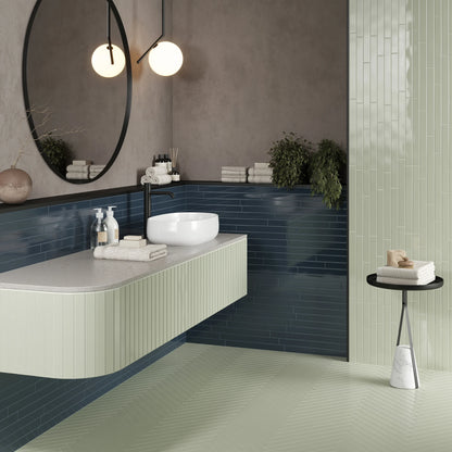 Keradom Twiggy 'Blu Petrolio', hier glanzende petrolblauwe wandtegels naast een mintgroene wand en visgraatvloer