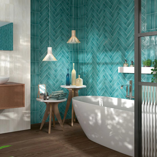 Estudio Cerámico Vermont 'Tiffany', turquoise wandtegels in visgraatverband achter een vrijstaand bad met hanglampen