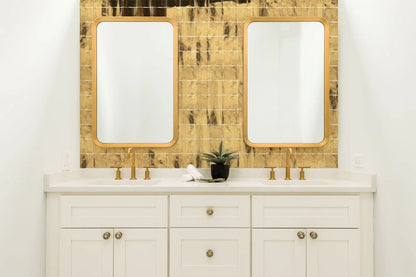 Tebe Vintage 'Gold', goudkleurige glanzende wandtegels achter een wit dubbel wastafelmeubel met twee spiegels