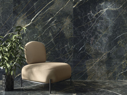 Baldocer Cerámica Wacom 'Wacom Moss', donkergroene marmerlook wandtegels achter een beige fauteuil en een plant
