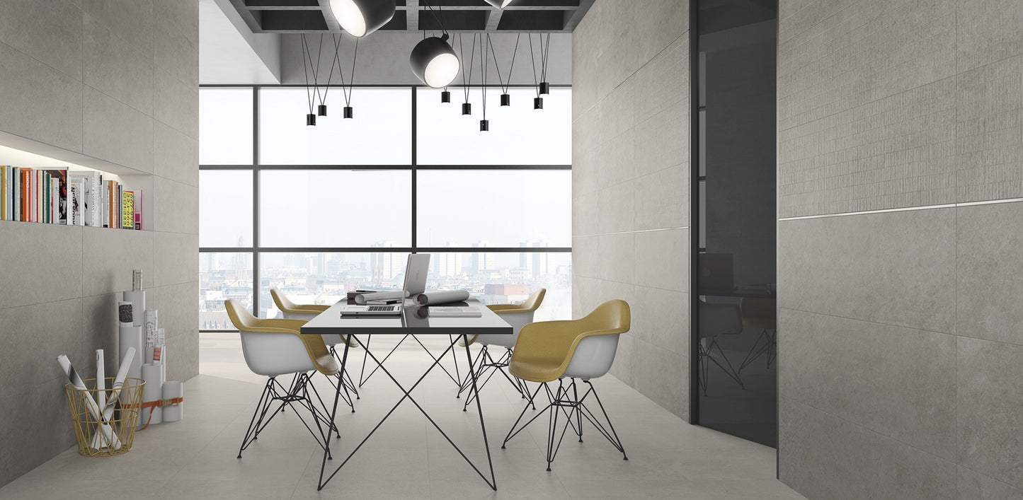 Argenta Cerámica Wave 'Concrete', grijze betonlook wandtegels in een kantoorruimte met vergadertafel, stoelen en raam