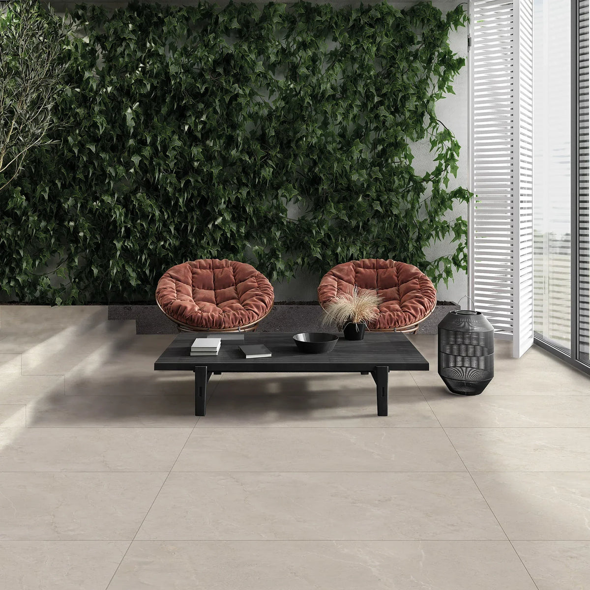 EnergieKer Wonder 'Sleet Mosaico', crème vloertegels, hier 120x120cm, op een terras met klimopwand en rotan stoelen
